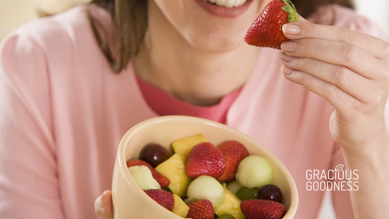 Photo-of-a-woman-eating-fresh-strawberries-in-a-bowl